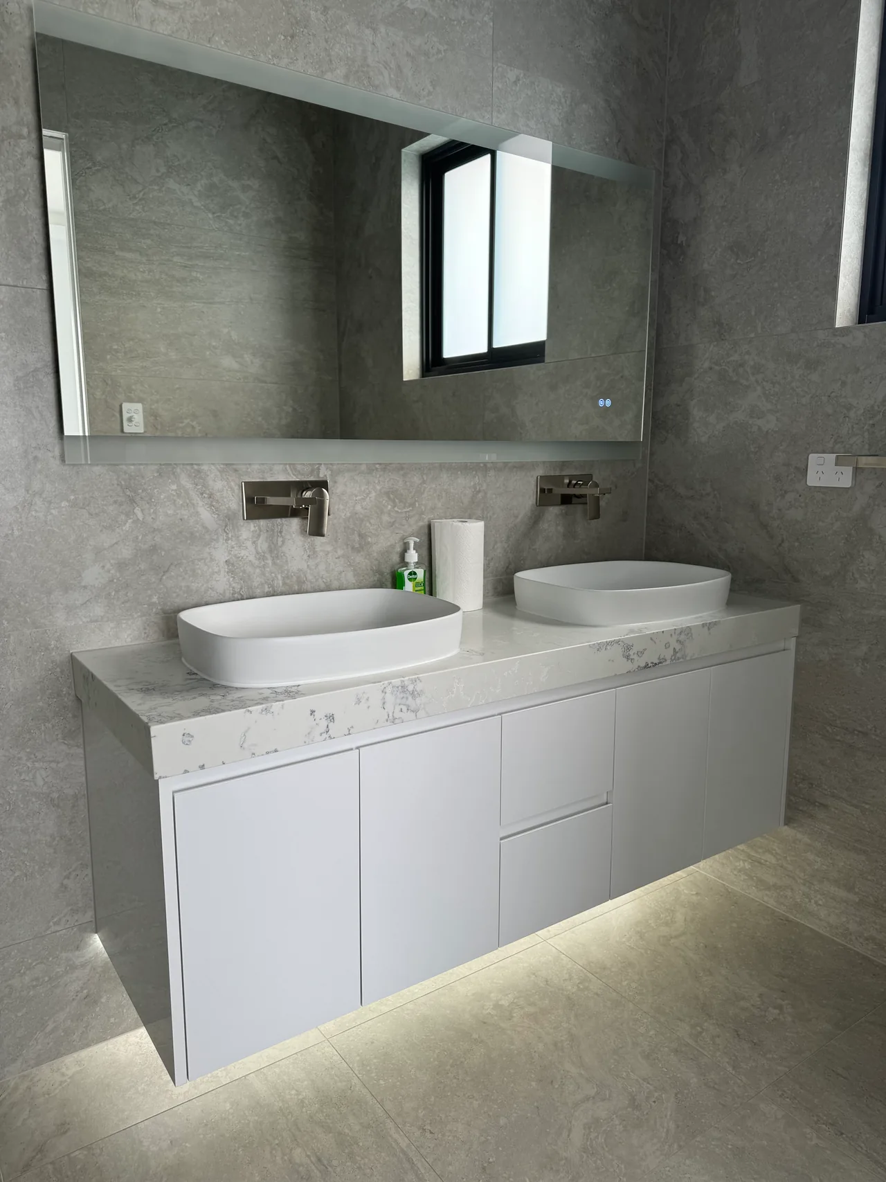 Detail of the Edensor Park vanity with twin white basins, wall-mounted taps and grey tiled walls