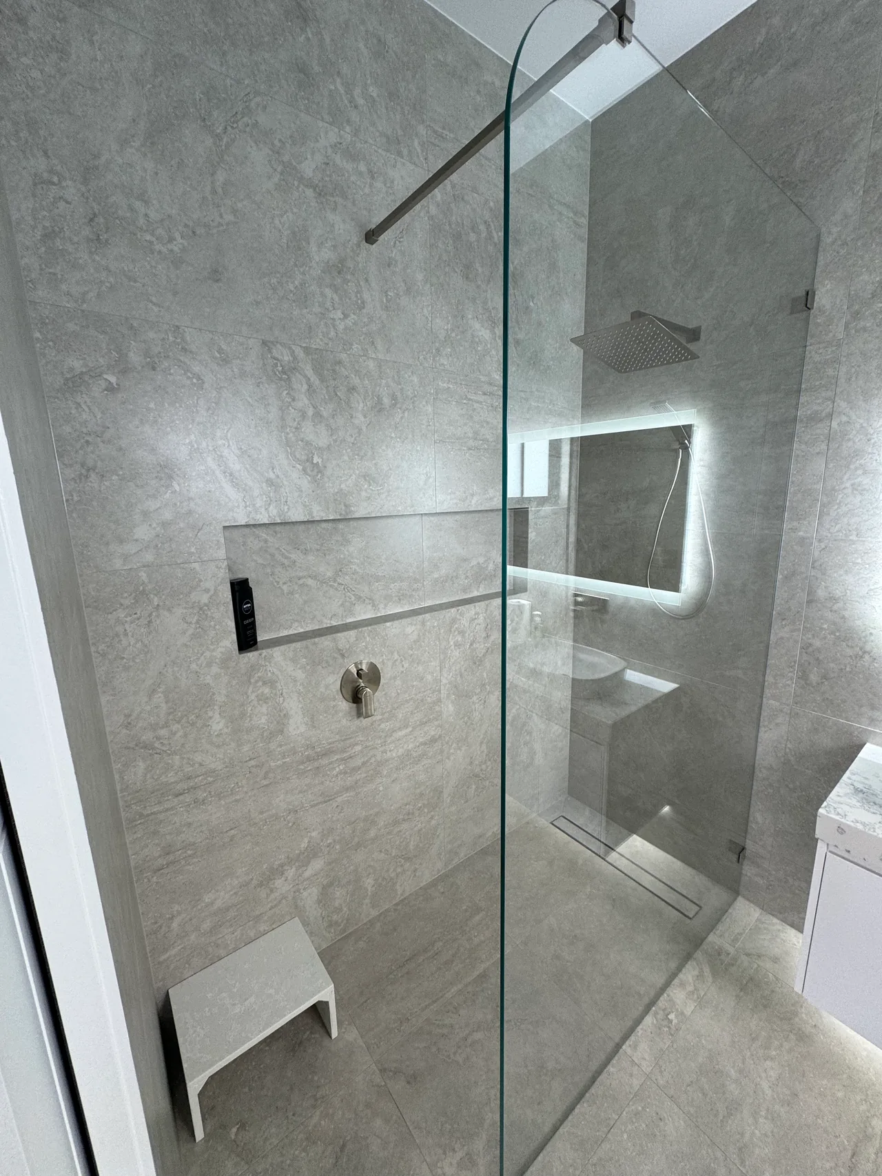 Edensor Park shower with a clear glass screen, overhead shower, recessed niche and linear drain