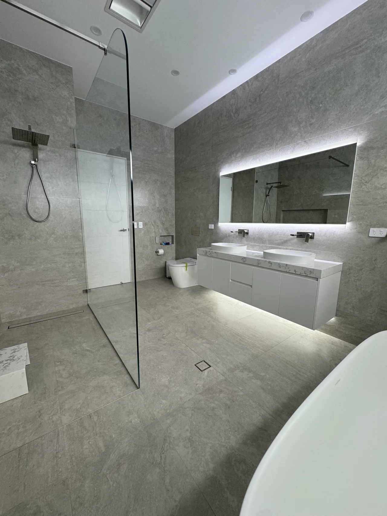 Completed Edensor Park bathroom with a double vanity, glass shower and freestanding bath
