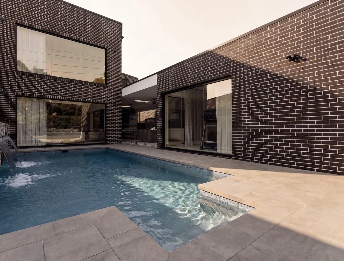 Rear brick elevation and swimming pool at Sash, Leppington